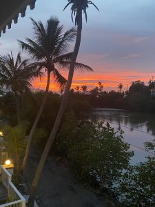 Sunset over the water and palm trees at Coconut Coast Villas
